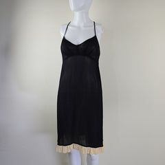 Black dress on a mannequin against a plain background
