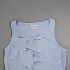 Light blue sleeveless top with a brand label on a tiled floor
