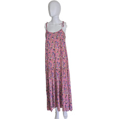 Folded pink floral dress on a mannequin against a white wall.