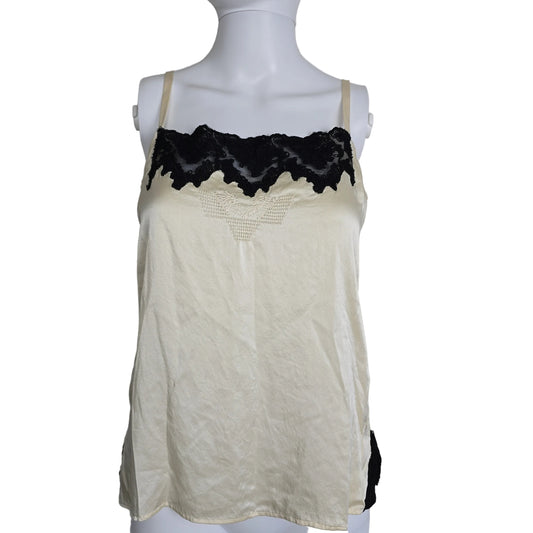 Mannequin wearing a white top with black lace details on a plain background 2736