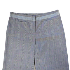 Folded blue checkered pants on a tiled floor