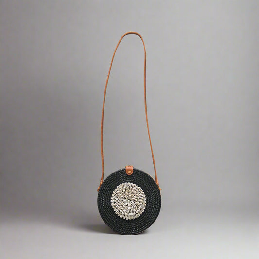 Black woven handbag with a brown strap on a tiled floor 1024