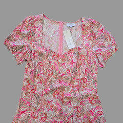 Pink and white patterned garment on a tiled floor with a visible brand tag.