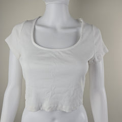 White sleeveless top on a mannequin against a neutral background