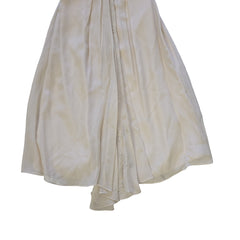 Folded white dress with lace trim on a tiled floor