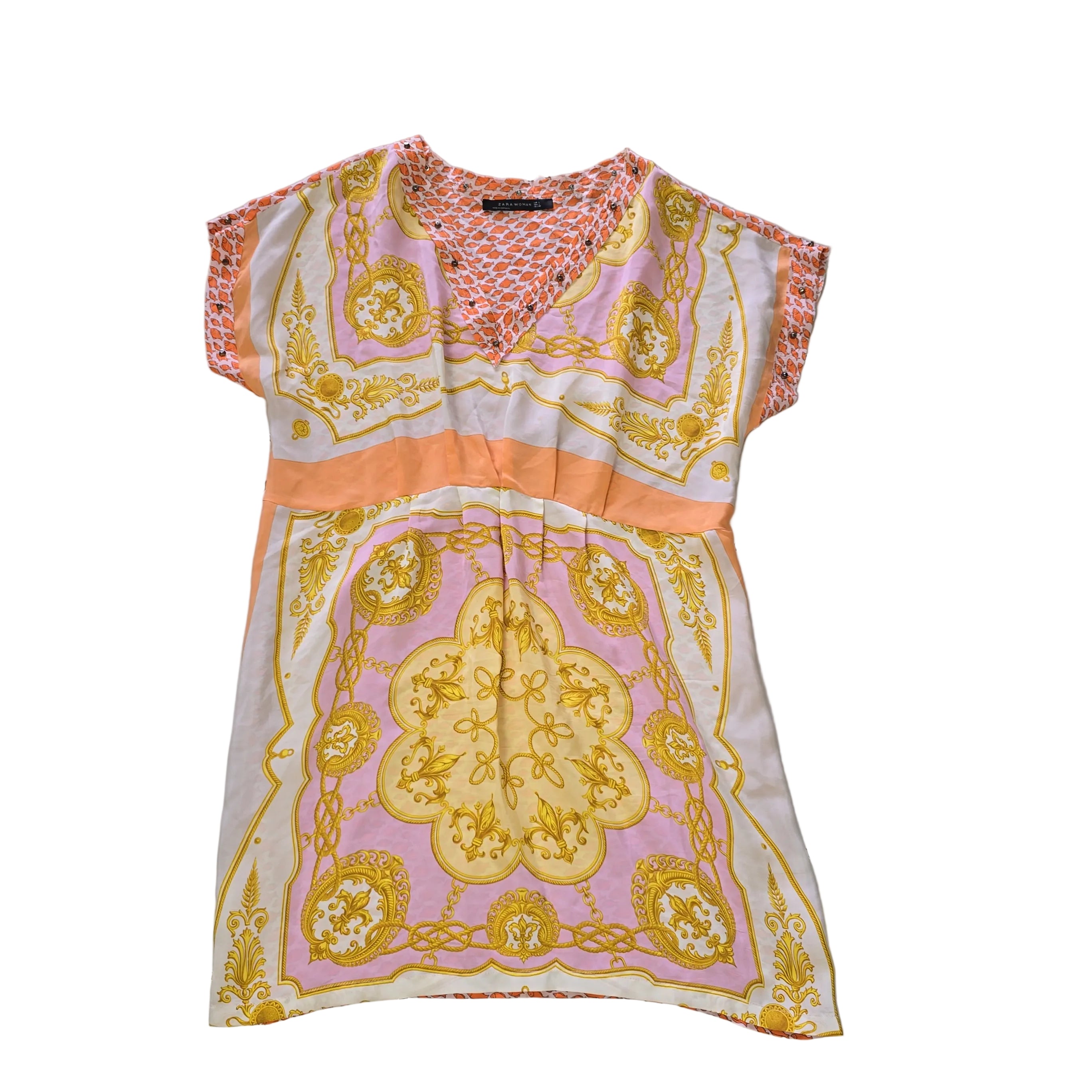 Decorative pink and yellow patterned fabric kaftan on a light background.