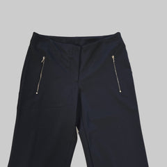 Black pants with zippers on a light tiled floor