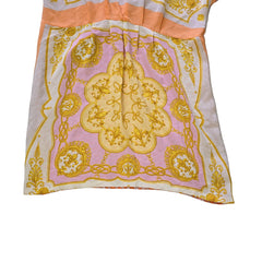 Decorative pink and yellow patterned fabric kaftan on a light background.