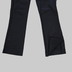 Two black pant legs laid flat on a tiled floor.