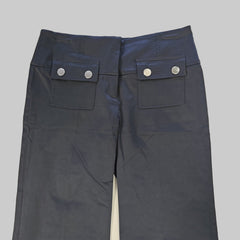 Black pants with button details on a tiled floor