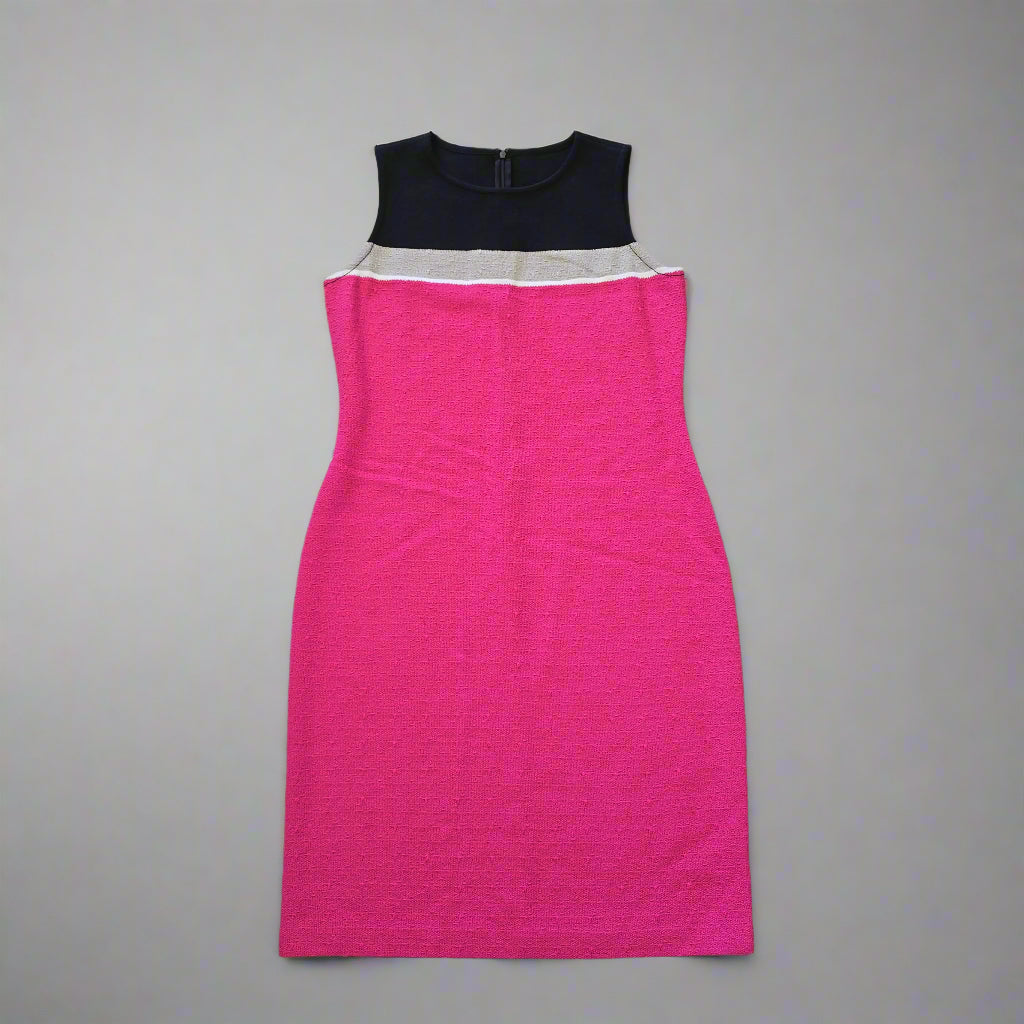 Pink dress and black item on a tiled floor