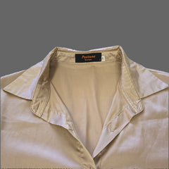 Beige top with a brand label on a white background